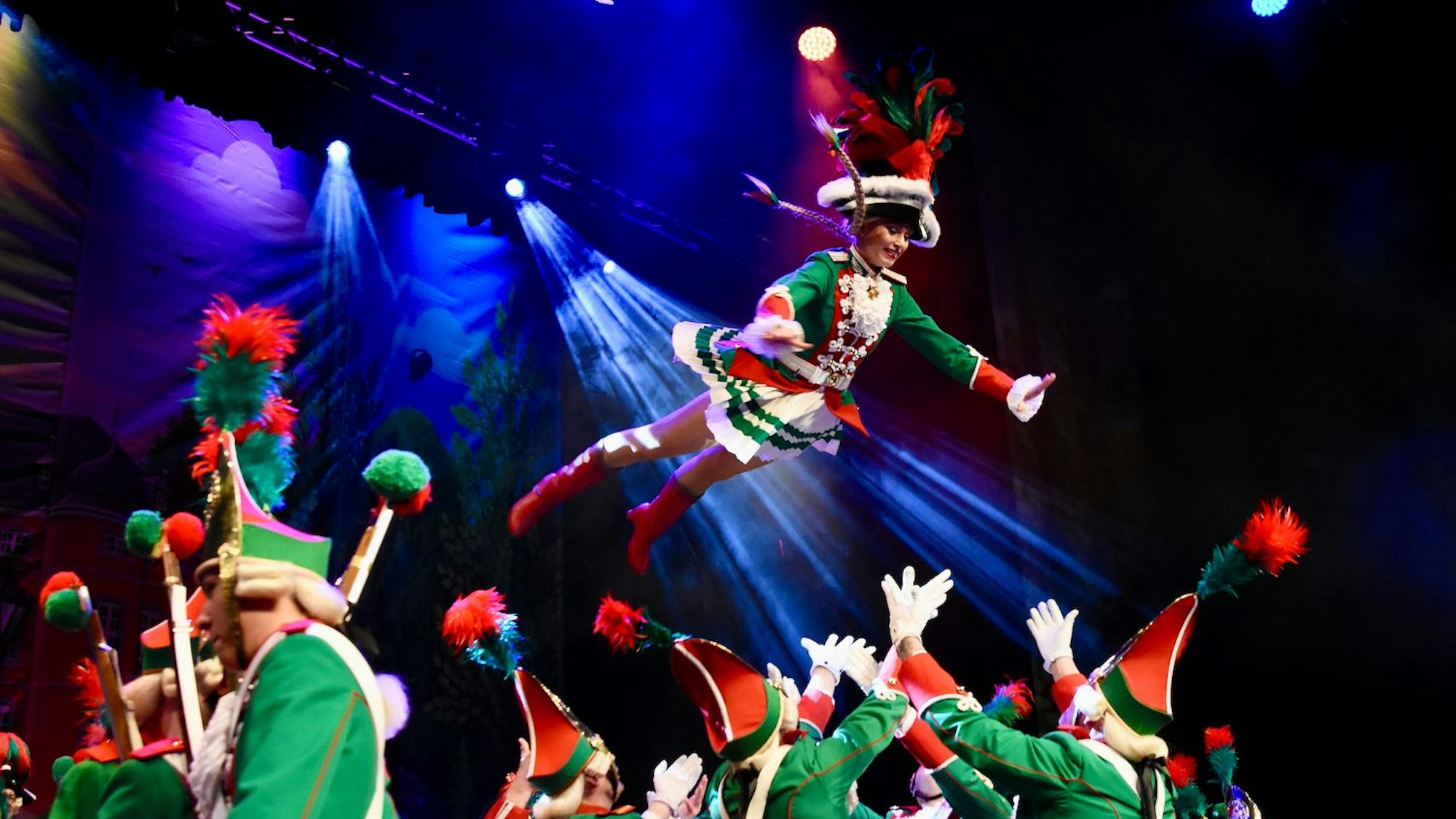 Ein Funkenmariechen wird von ihrer Tanzgarde in die Luft geworfen.