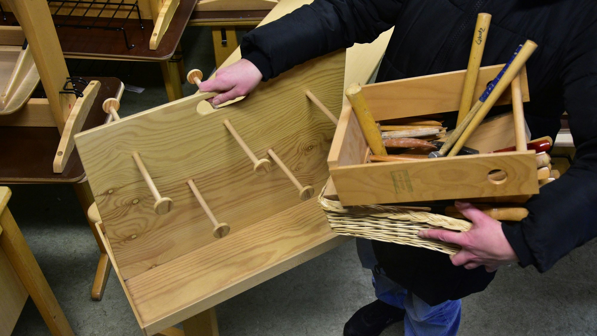 Anne Jung nimmt eine Kopfhörerhalterung und Werkzeug mit.