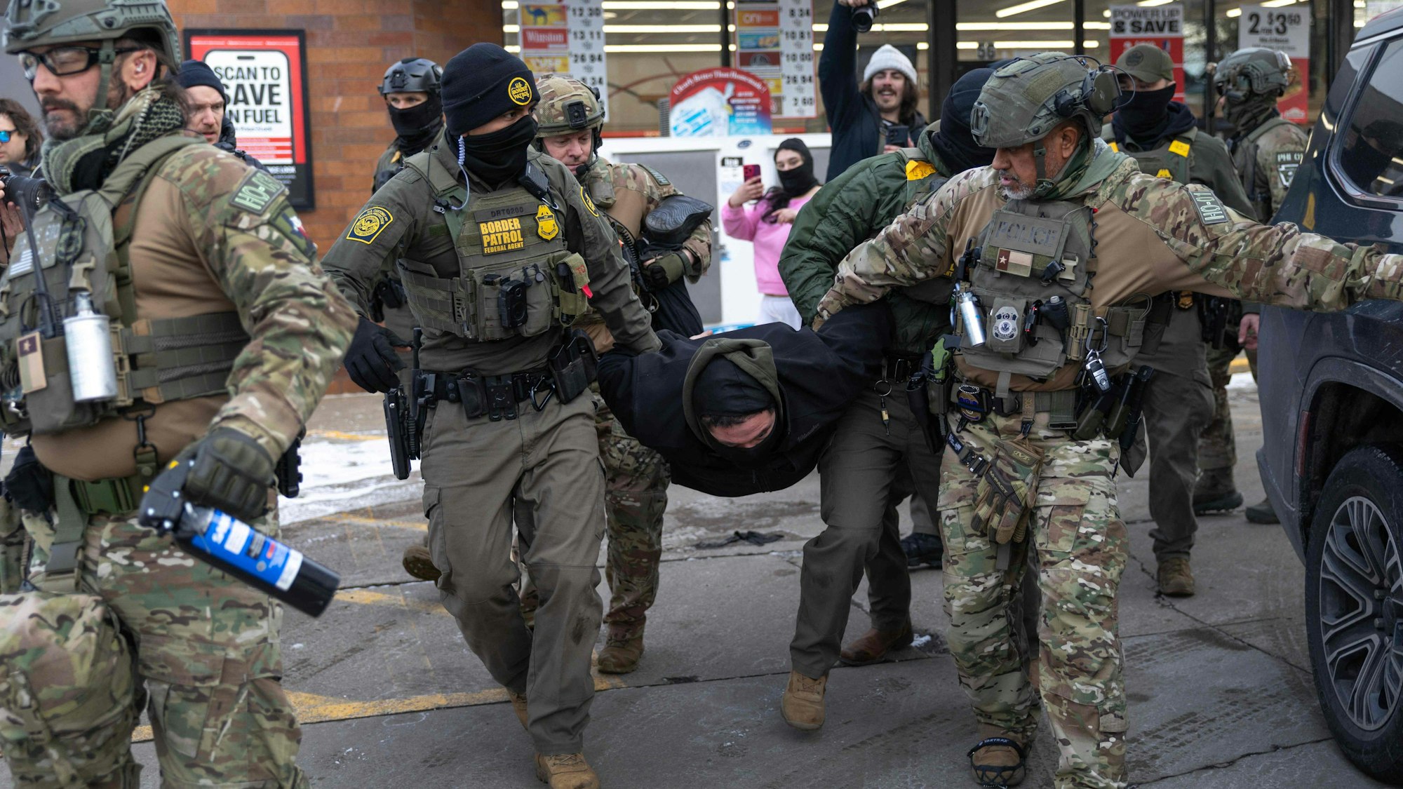 US-Grenzschutzbeamte nehmen einen Aktivisten in Gewahrsam, nachdem es an einer Tankstelle in St. Paul, Minnesota, zu einer Auseinandersetzung gekommen war. Die Regierung Trump hat schätzungsweise 2000 Bundesbeamte in die Region geschickt, um verstärkt nach undokumentierten Einwanderern zu fahnden.