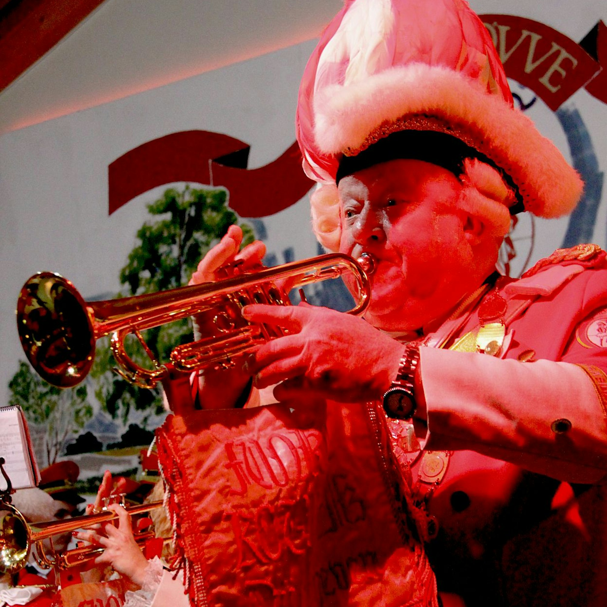 Ein älterer Mann in der Uniform der KG Heimat spielt Trompete.