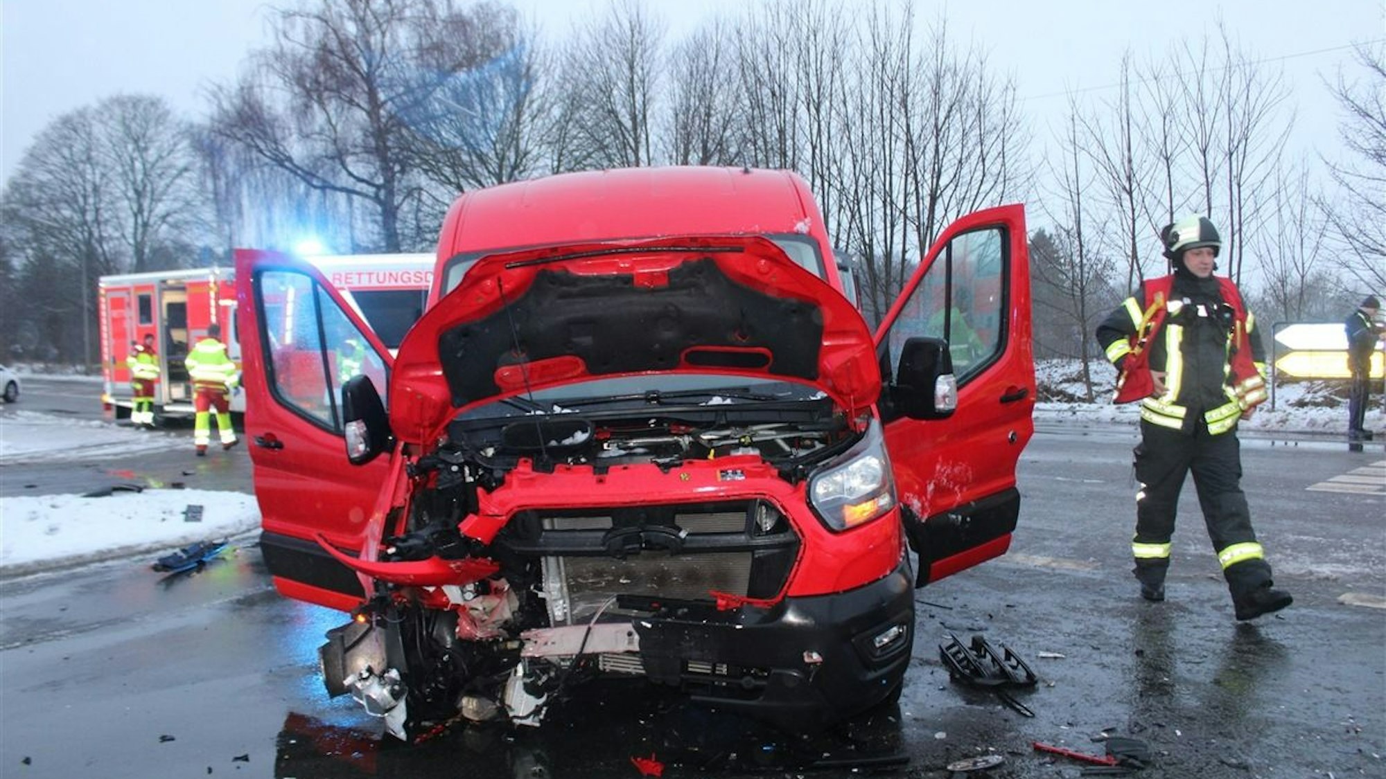 Ein verunfalltes Auto steht am Straßenrand, im Hintergrund sind Einsatzkräfte der Polizei zu sehen.