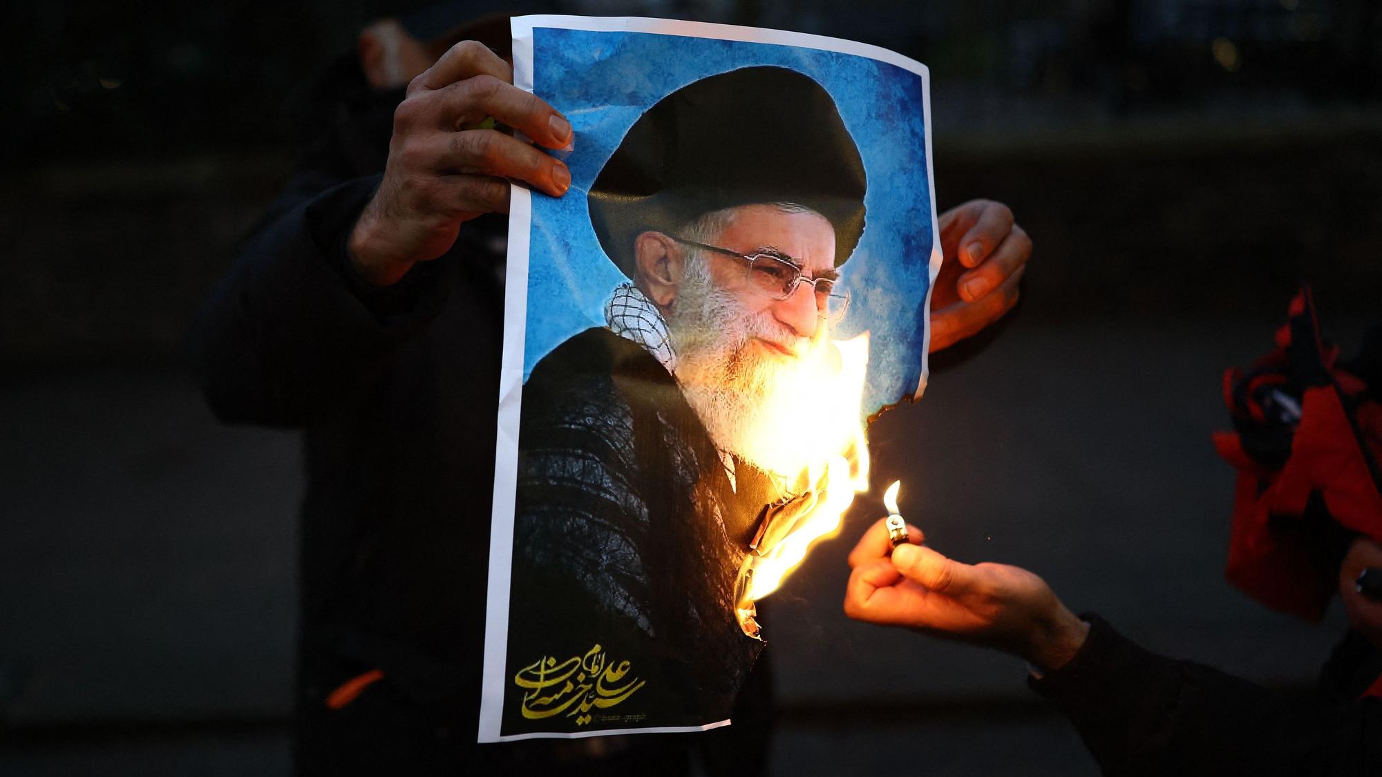 Protestierende zünden vor der iranischen Botschaft in London ein Bild von Ajatollah Ali Chamenei an. Der oberste Führer des Irans soll laut einem Bericht die Tötung tausender Menschen angeordnet haben. (Archivbild)