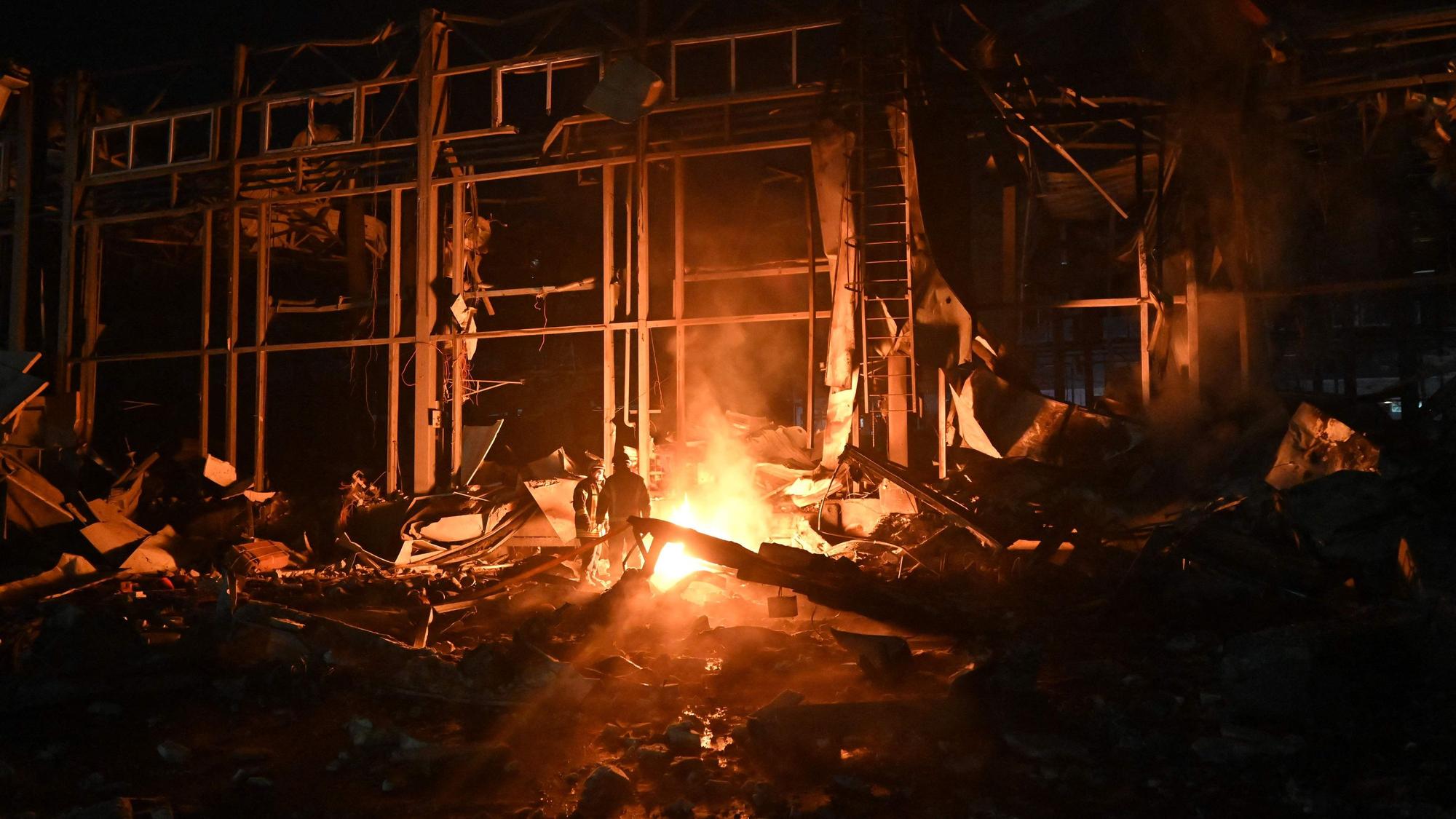Ukrainische Feuerwehrkräfte arbeiten an der schwerbeschädigten Niederlassung des Postunternehmens Nova Poshta nach einem Luftangriff in einem Dorf außerhalb von Charkiw.
