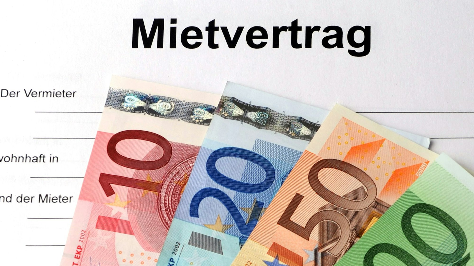 Geldscheine liegen auf einem Mietvertrag.