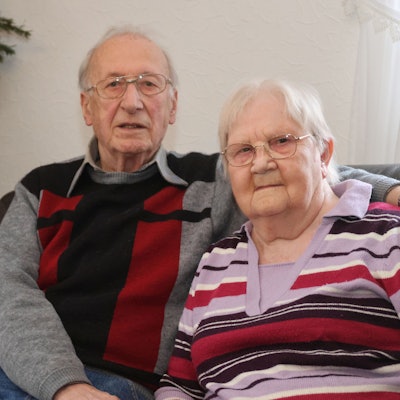 Helene und Christian Hüttling sitzen Arm in Arm nebeneinander.