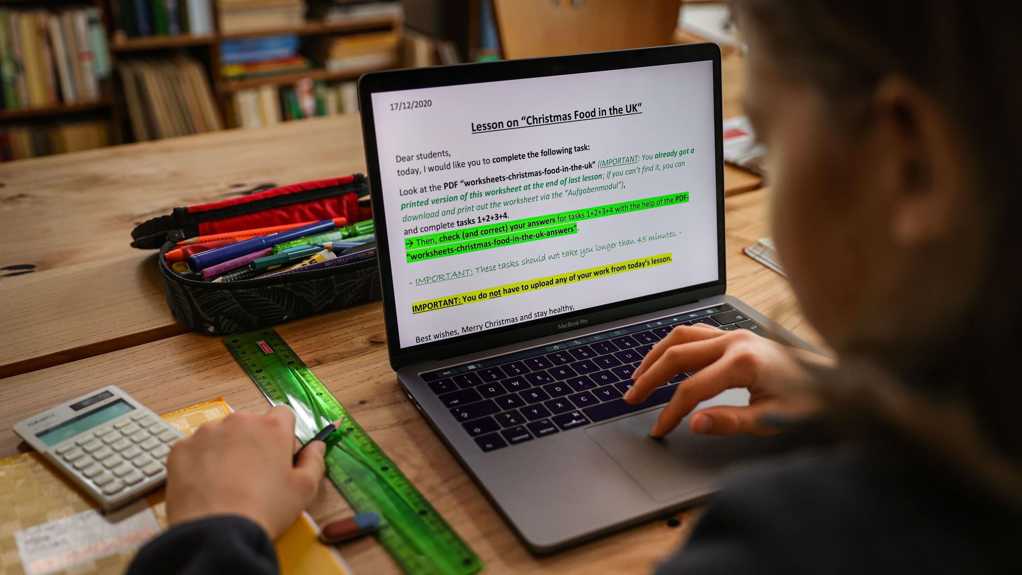 Ein Schüler löst am Laptop zu Hause seine Schulaufgaben, die ihm seine Lehrer für den Tag über den Schulserver geschickt haben.