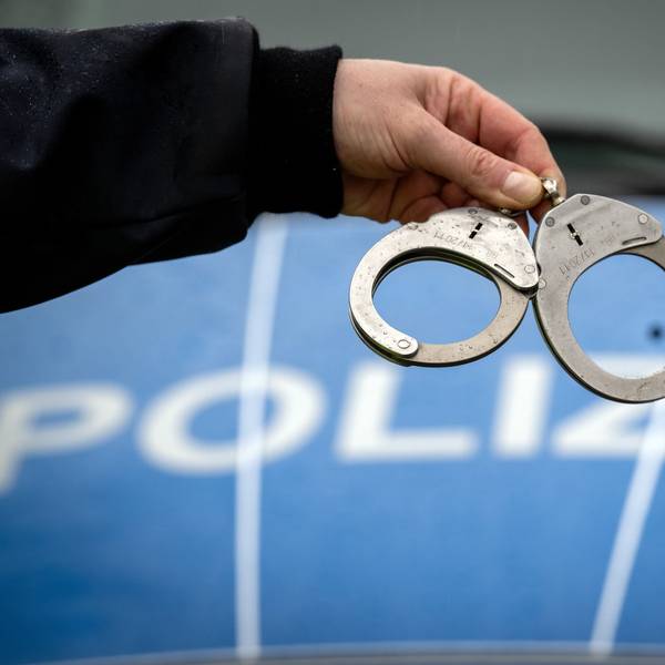 Ein Polizist hält ein Paar Handschellen