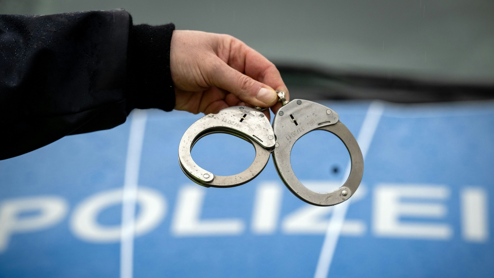 Ein Polizist hält ein Paar Handschellen