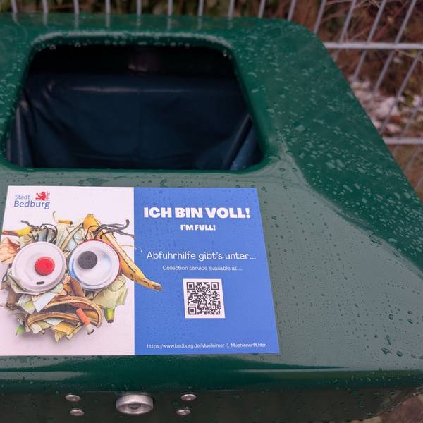 Zu sehen ist ein Aufkleber auf einem öffentlichen Mülleimer.