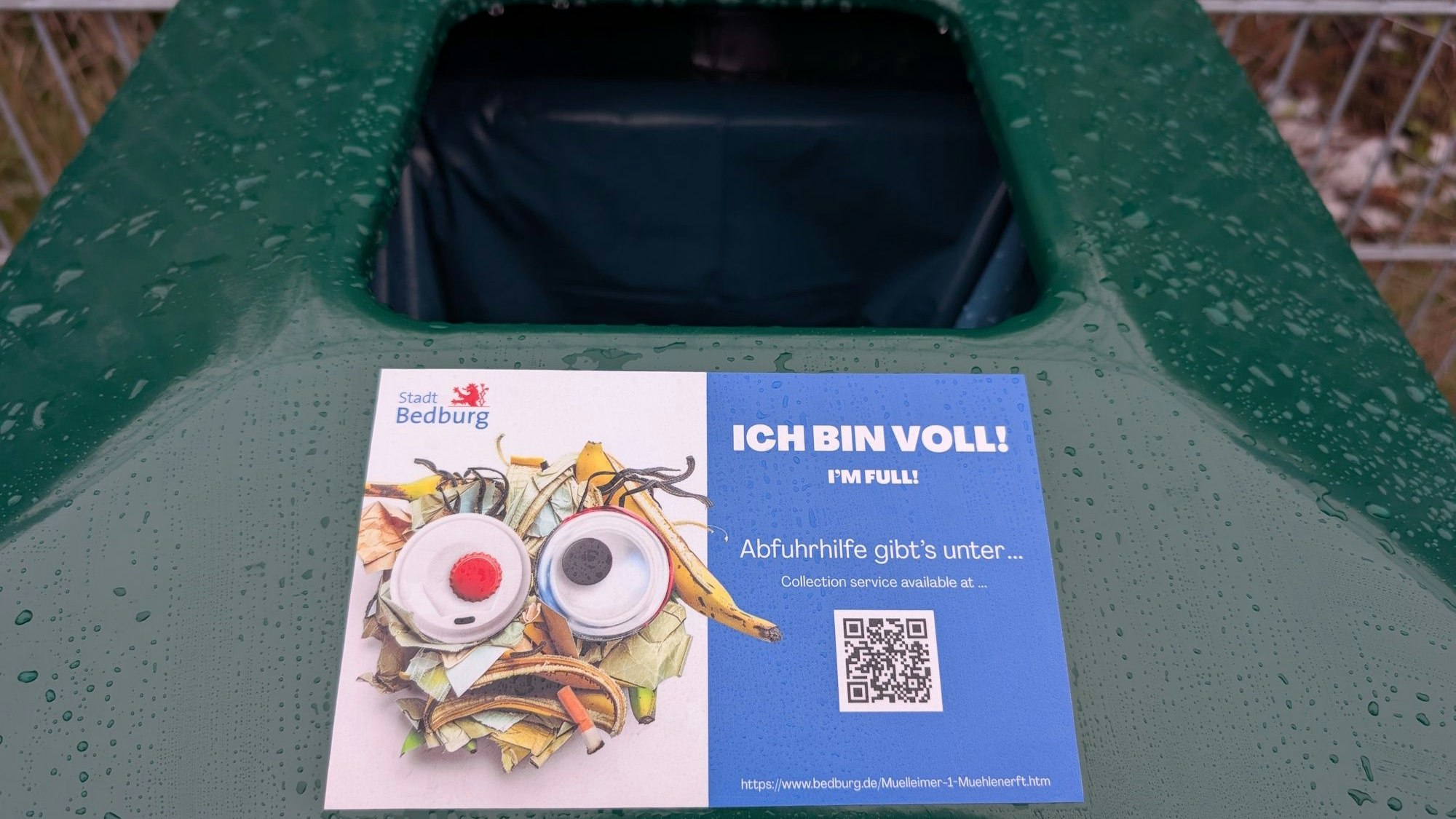 Zu sehen ist ein Aufkleber auf einem öffentlichen Mülleimer.