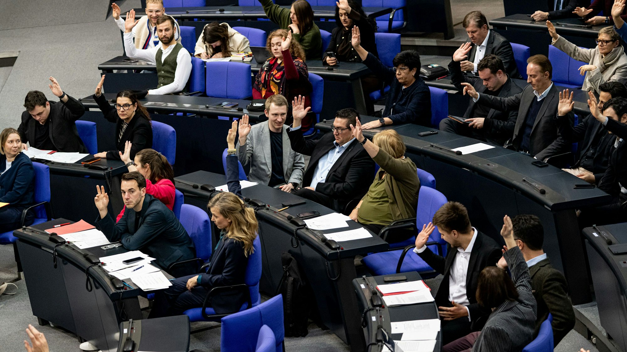Abgeordnete stimmen bei einer Plenarsitzung im Deutschen Bundestag mit Handzeichen ab. Am Donnerstag wird debattiert, auf welche Gelder ukrainische Geflüchtete künftig hoffen können.