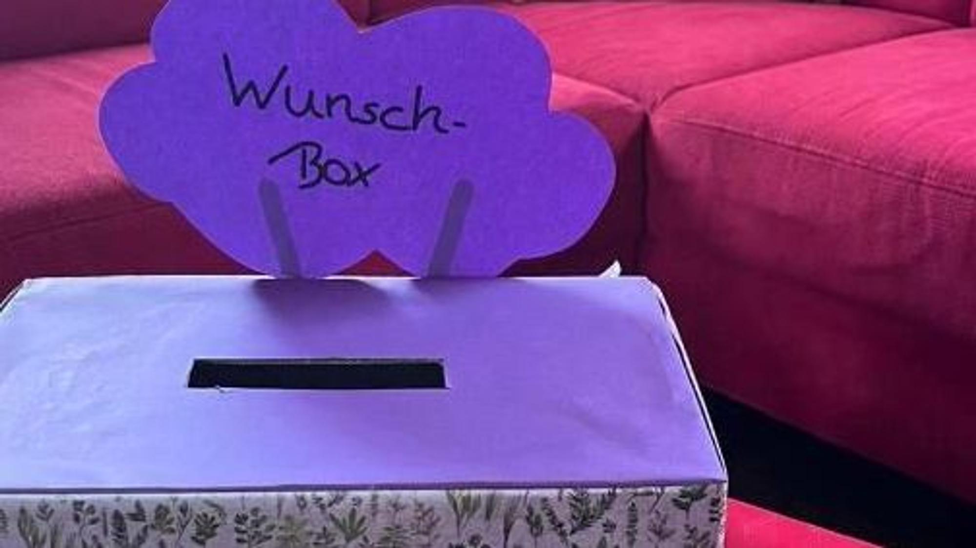 Eine fliederfarbene Wunschbox kann mit Ideen und Wünschen für die Ojo gefüllt werden.