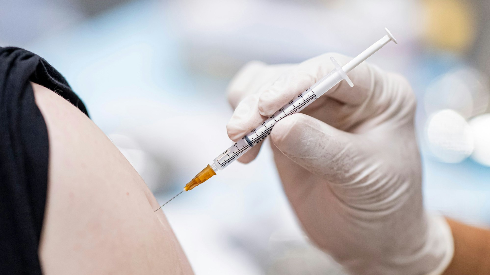 Ein Arzt impft einen Kunden.