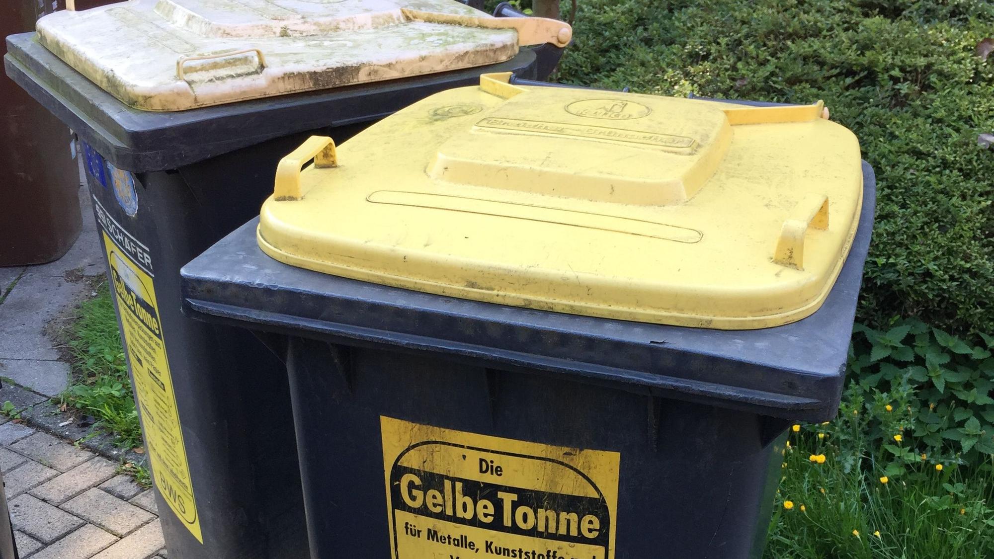 Zwei gelbe Tonnen stehen nebeneinander.