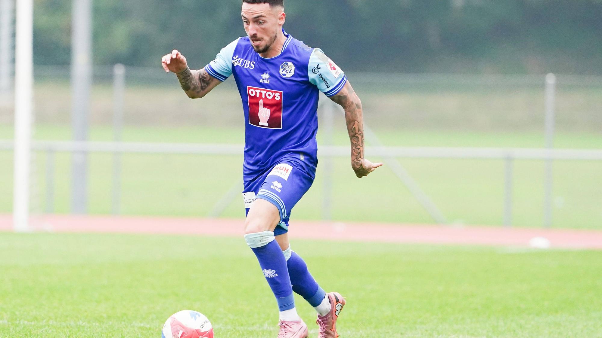 Sinan Karweina läuft mit dem Ball am Fuß über den Platz.