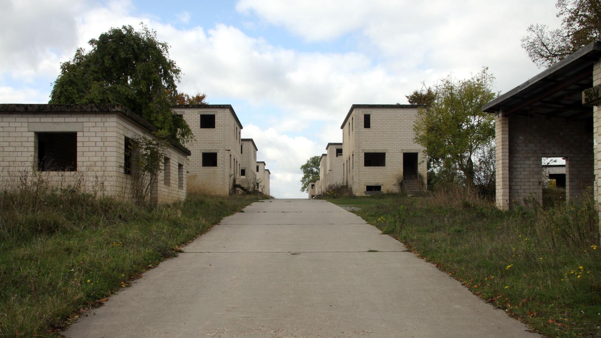 Rudimentäre Fassaden aus hellem Stein mit leeren Fenster- und Türöffnungen bilden eine Straßenzeile.