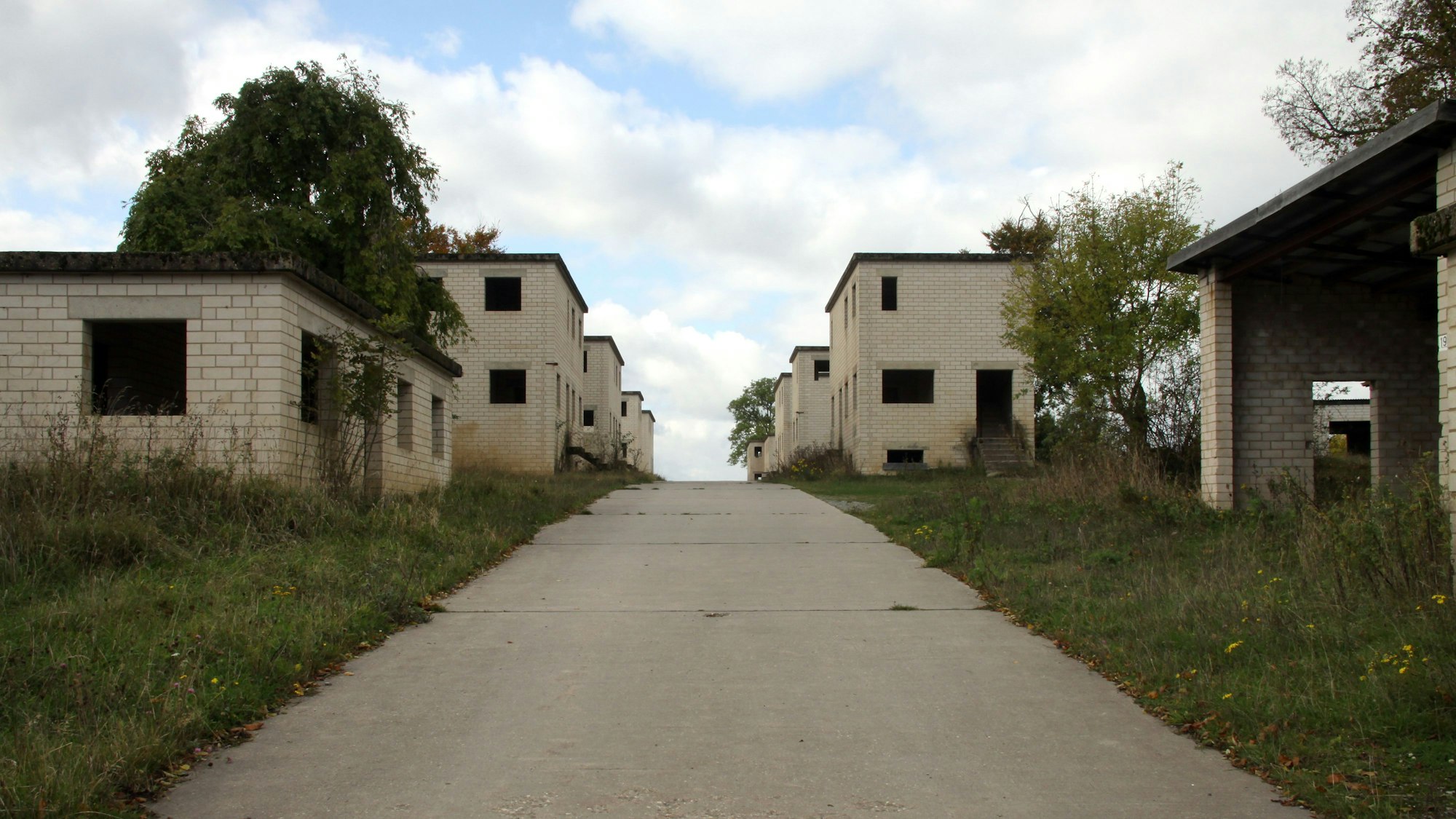 Rudimentäre Fassaden aus hellem Stein mit leeren Fenster- und Türöffnungen bilden eine Straßenzeile.