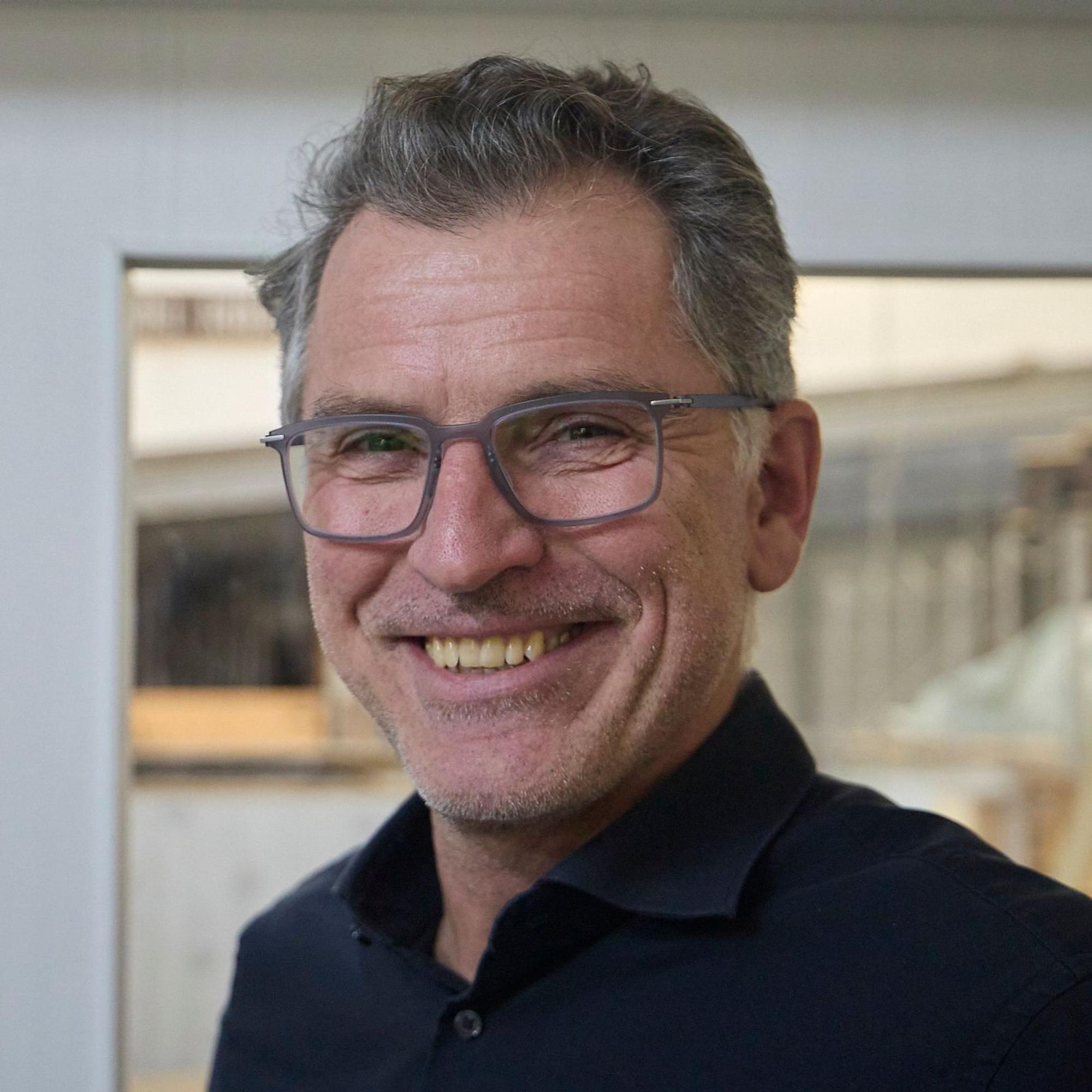 Porträtaufnahme von Frank Weimbs. Er trägt eine Brille und ein dunkelblaues Hemd.
