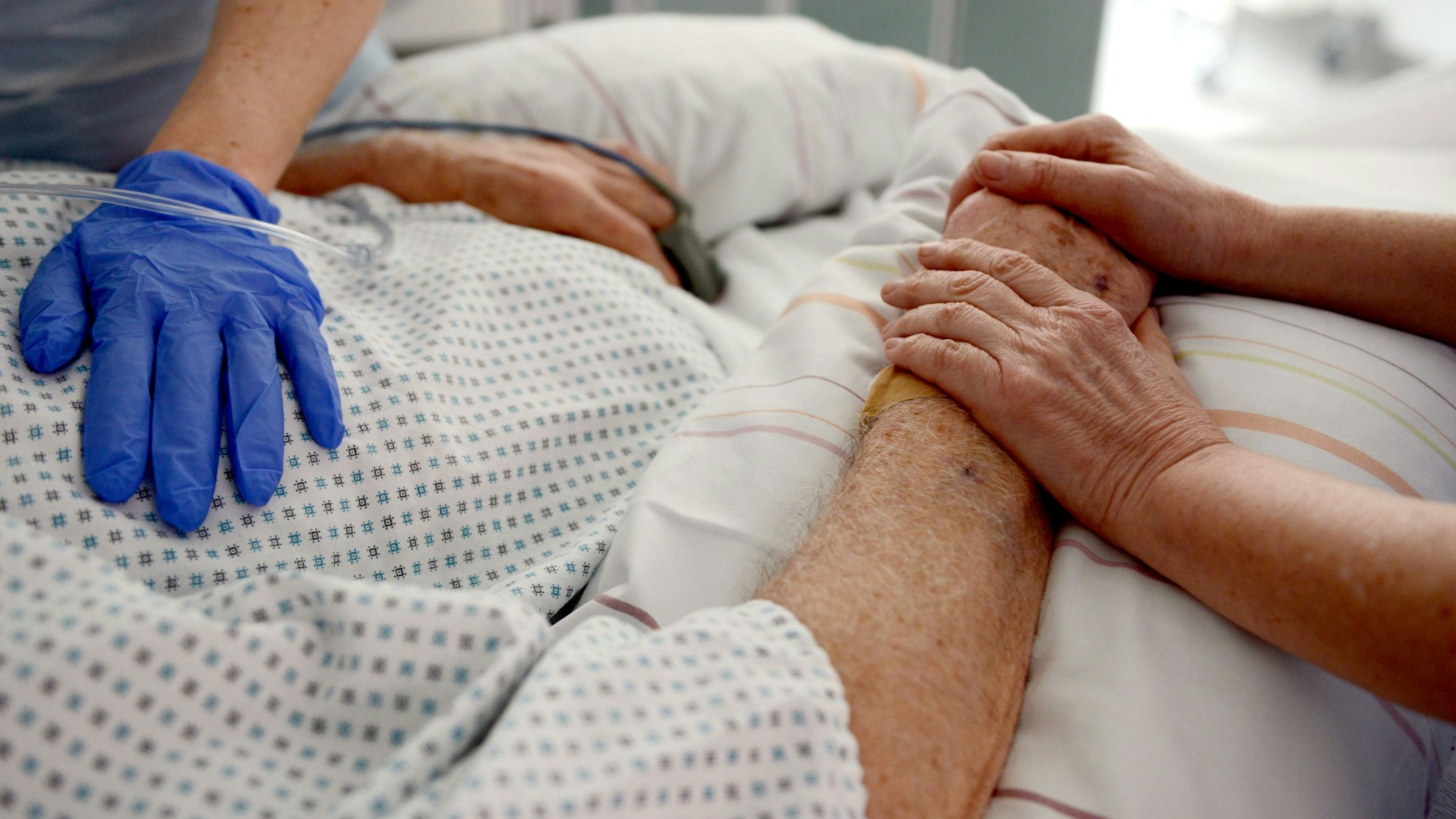 Krankenschwestern betreuen in einem Krankenhaus einen Patienten auf einer Intensivstation.