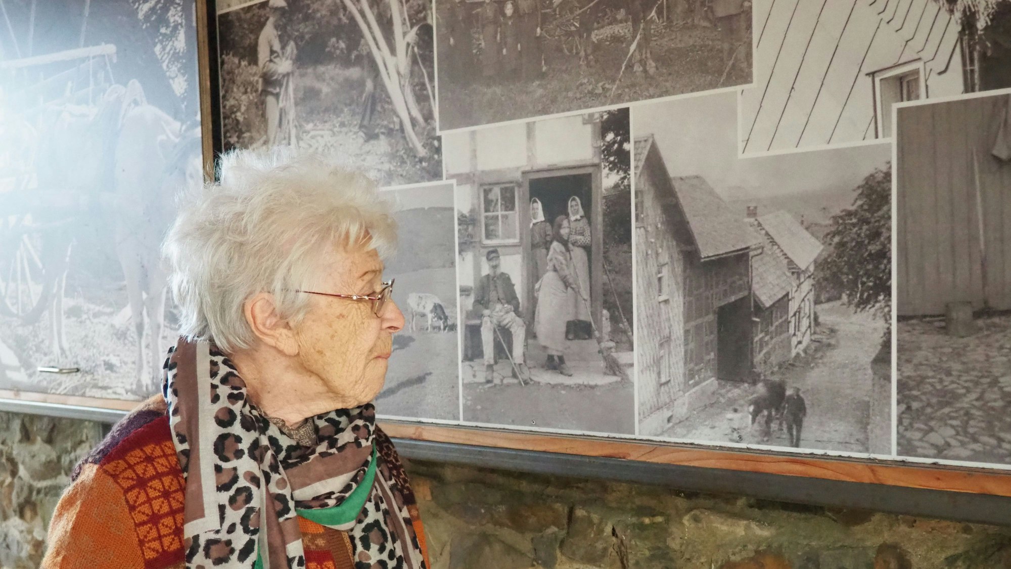 Christel Küpper blickt auf die großformatigen historischen Fotos an einer Wand in der alten Schule.