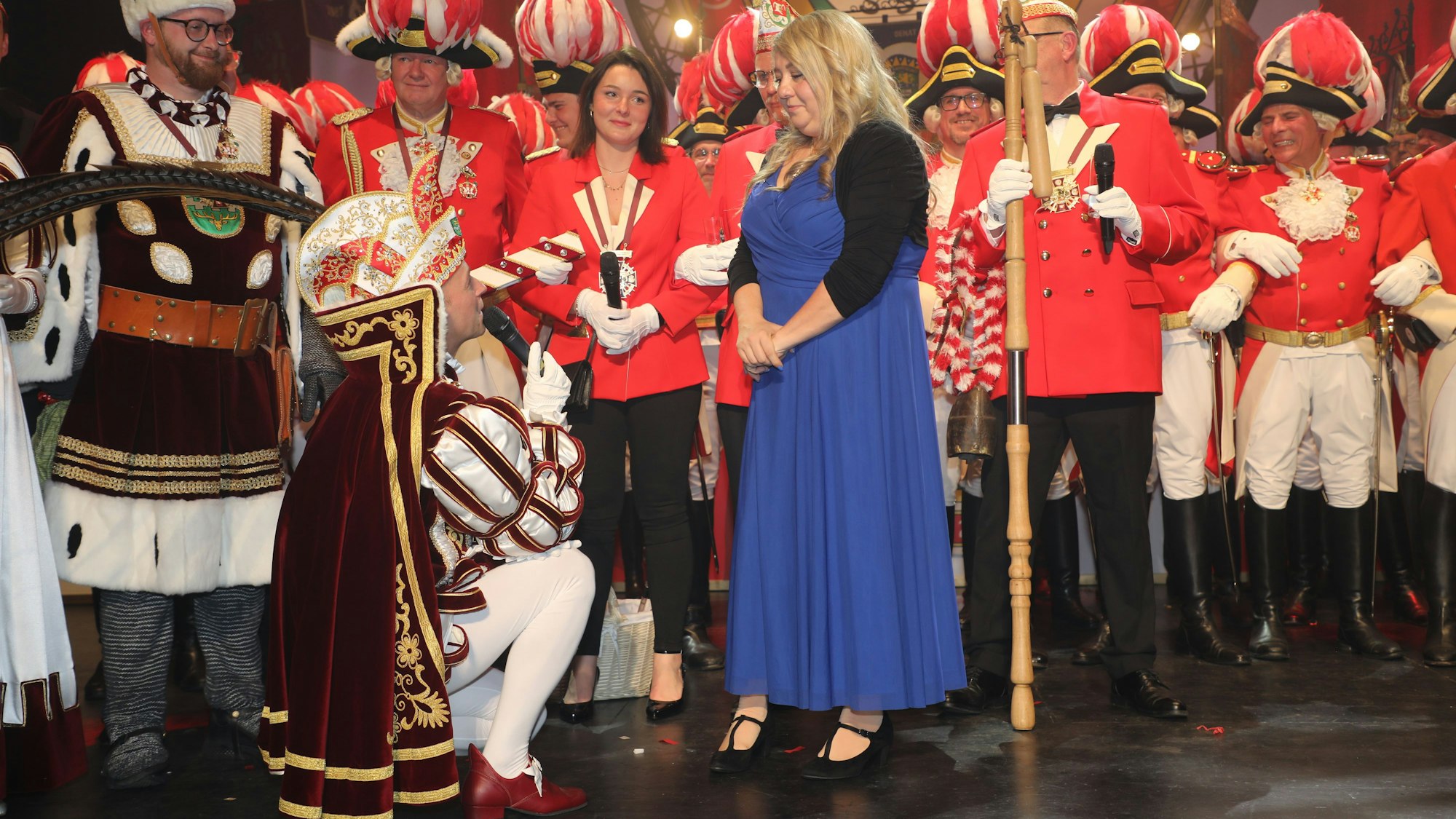 Prinz Thomas III. kniet auf dem Boden und macht „seiner“ Ramona einen Heiratsantrag auf der Proklamationsbühne im Bergischen Löwen.