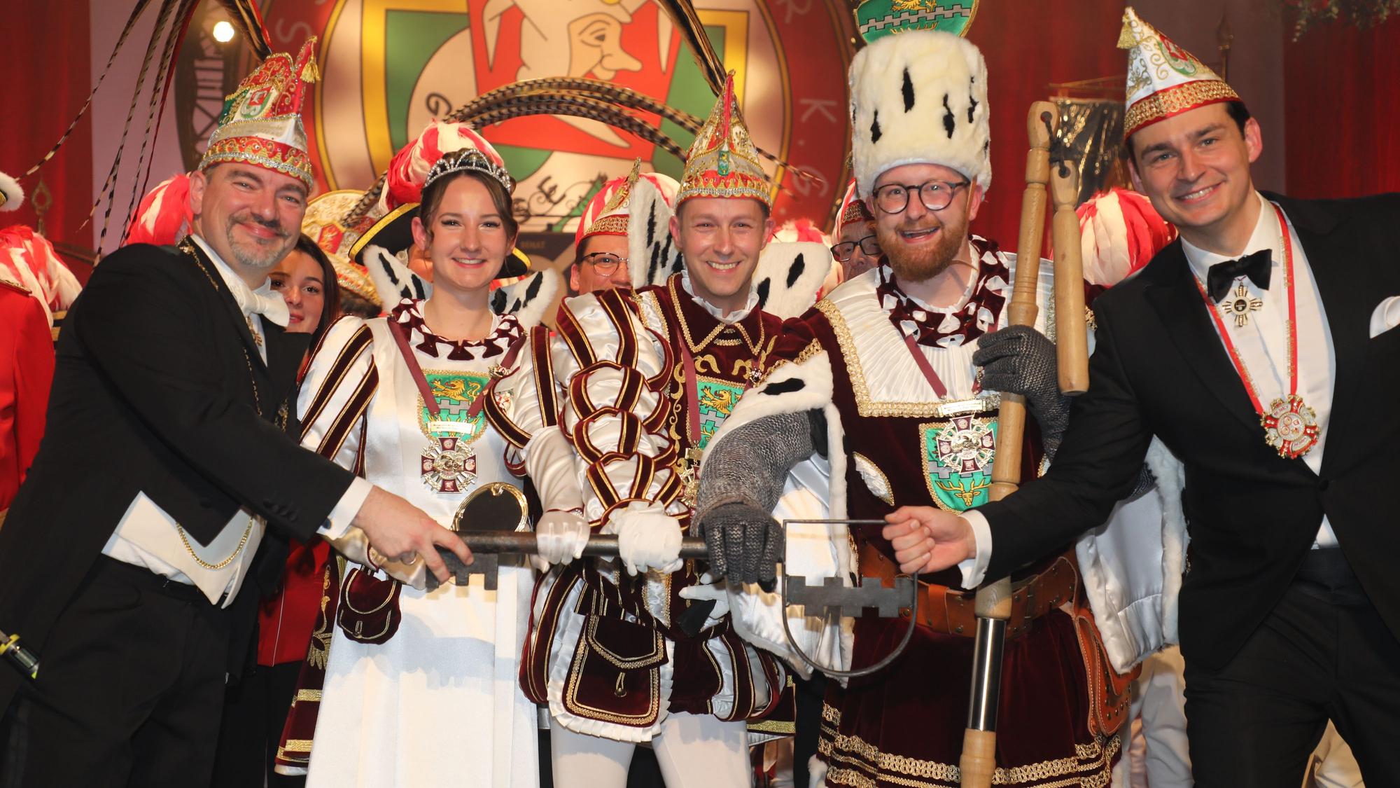 Bürgermeister Marcel Kreutz (r.) übergibt den Stadtschlüssel an das Dreigestirn von Prinz Thomas III. (Schmitz), Bauer Maurice (Jakobs) und Jungfrau Lea (Rodenbach) mit Große-Gladbacher-Präsident Alexander Pfister.