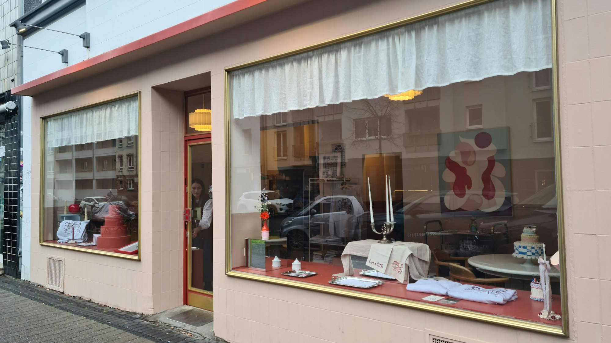Im Schaufenster eines Geschäfts sind Torten, Kerzenleuchter und Accessoires zu sehen.