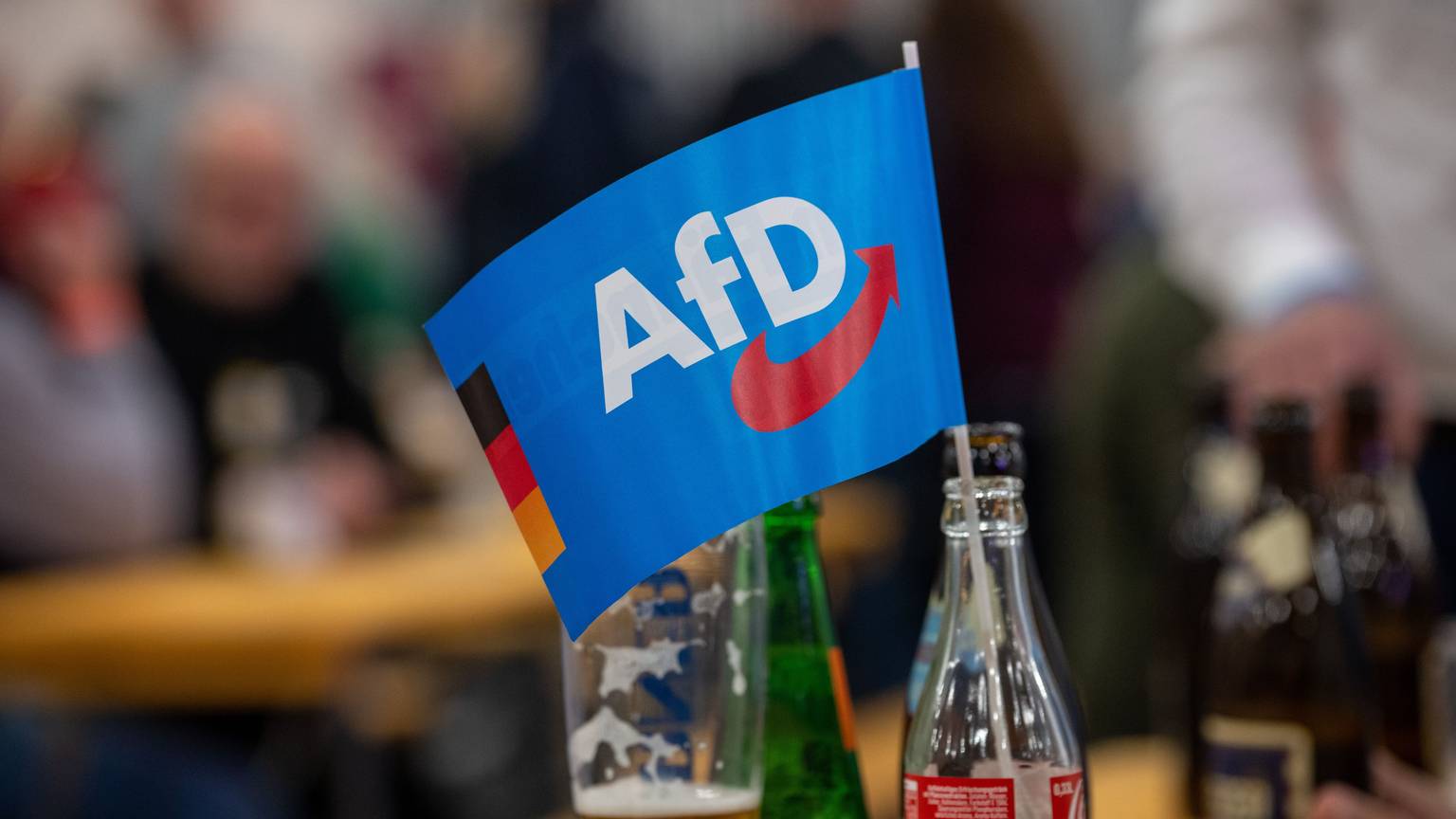Ein Fähnchen der Alternative für Deutschland (AfD) steckt in einer Flasche bei einer Veranstaltung. (Symbolfoto)