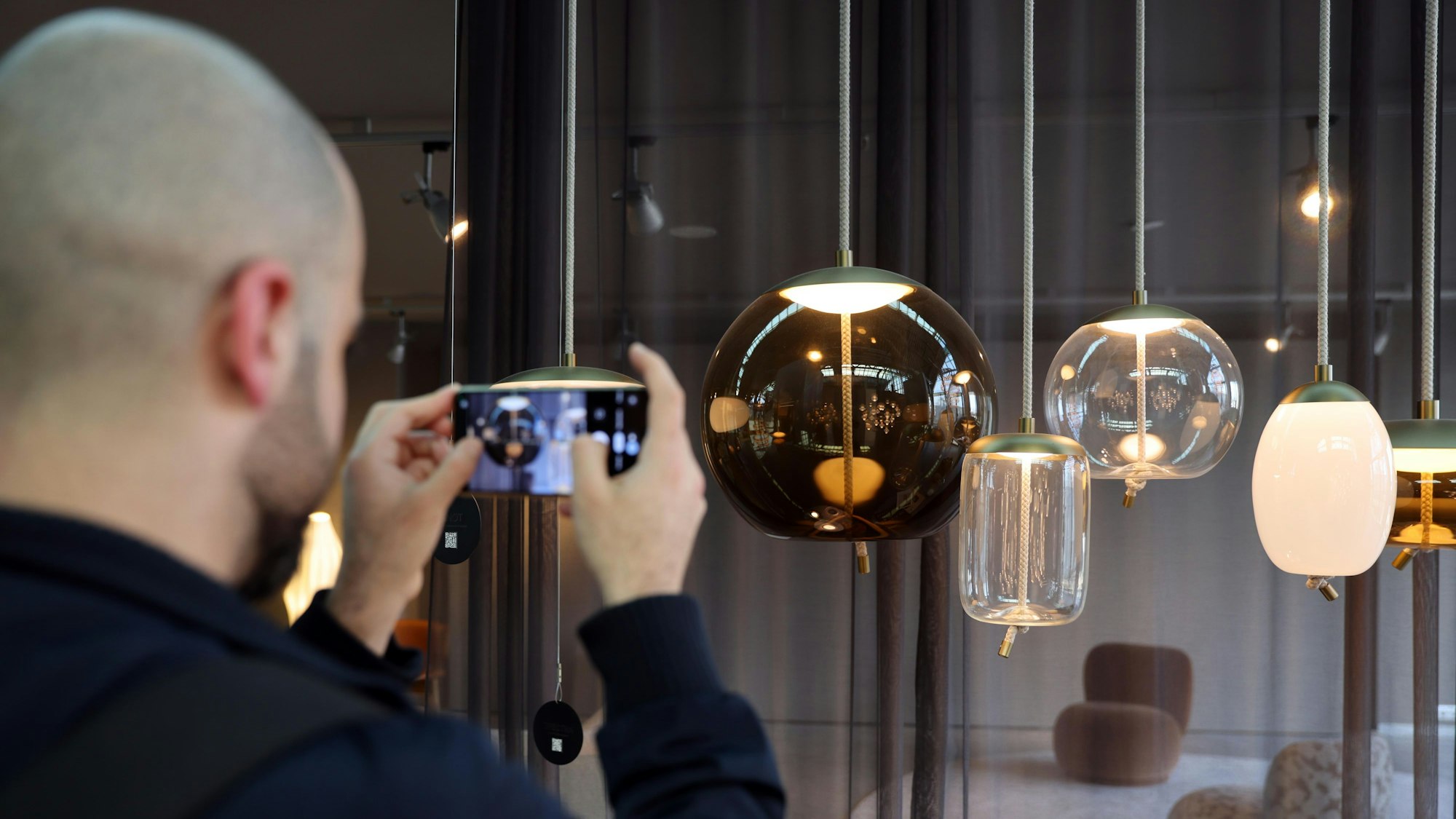 Ein Mann fotografiert Designer-Lampen.