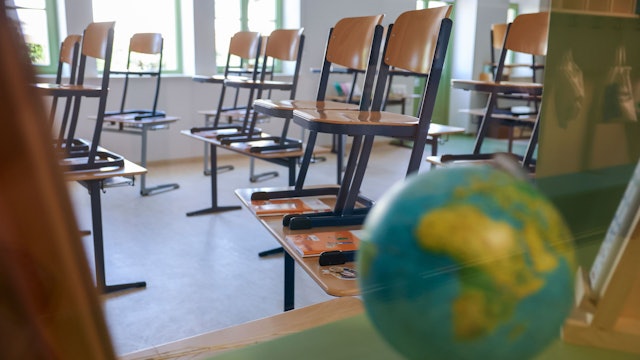 Stühle stehen auf Tischen in einem Klassenzimmer.