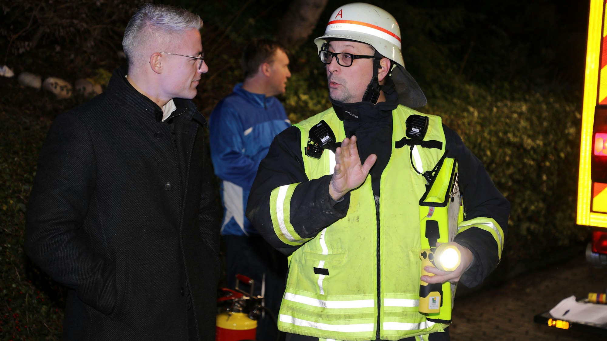Feuerwehrchef Bastian Eltner (r.) informiert Rösraths Bürgermeister Yannick Steinbach an der Einsatzstelle über die Lage.