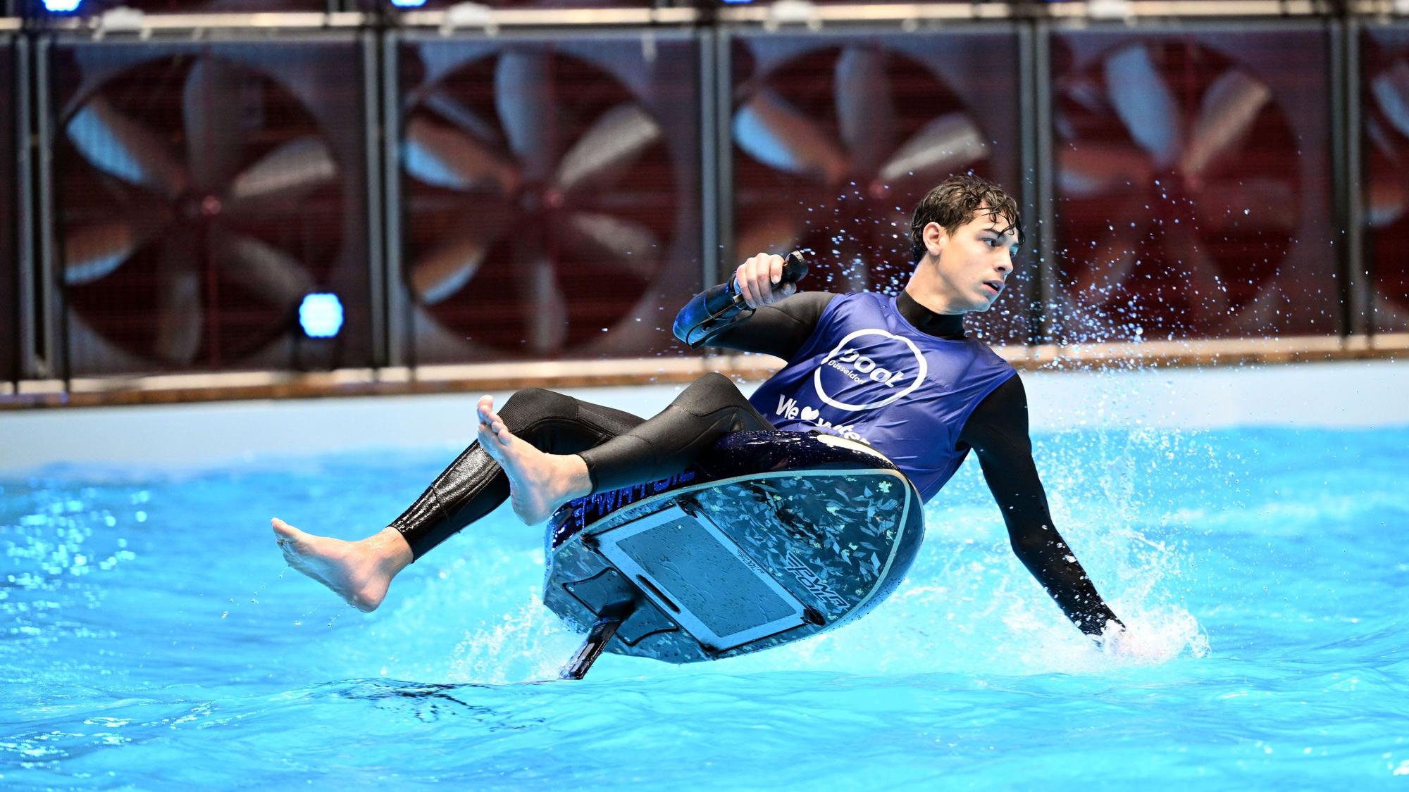 Ein E-Foiler fährt im Becken auf der Wassersportmesse boot eine Präsentationsrunde.
