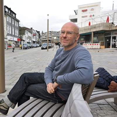 Molitor sitzt auf einer Bank.