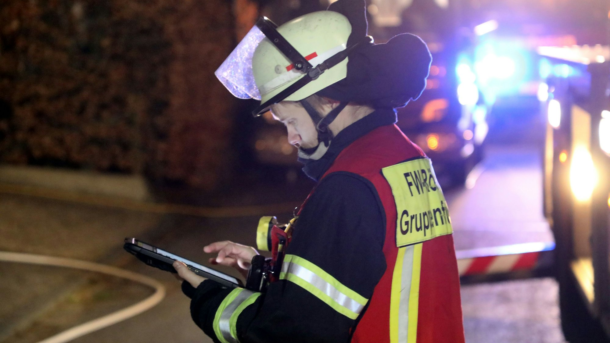 Ein Feuerwehrmann schaut auf ein Tablet.