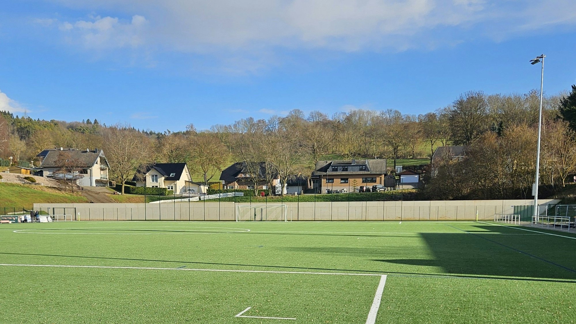 Blick auf den Kunstrasenplatz und die Betonwand.