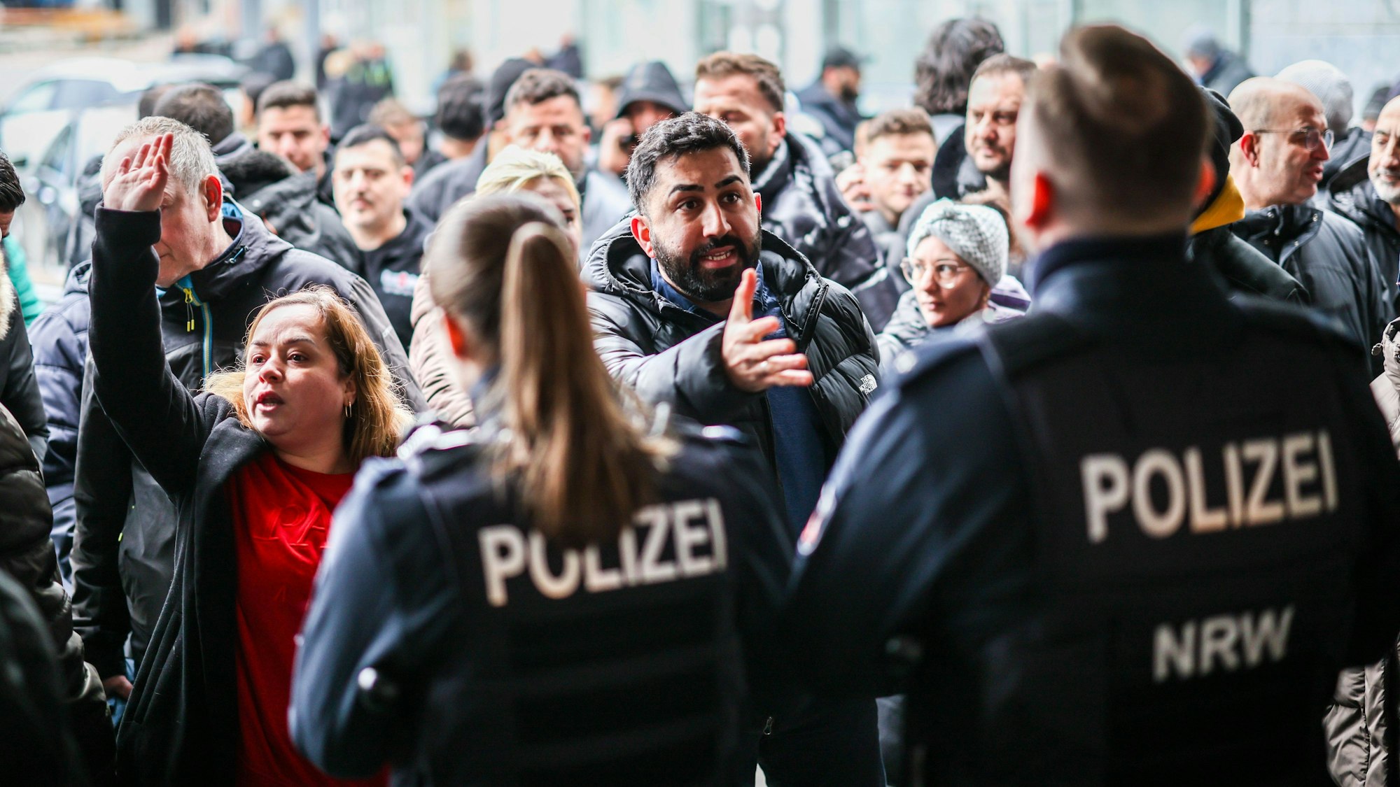 Aufgebrachte Kunden diskutierten vor der Sparkassenfiliale in Gelsenkirchen-Buer mit Polizeibeamten nach der Räumung des Vorraums der Filiale. (Archivbild)