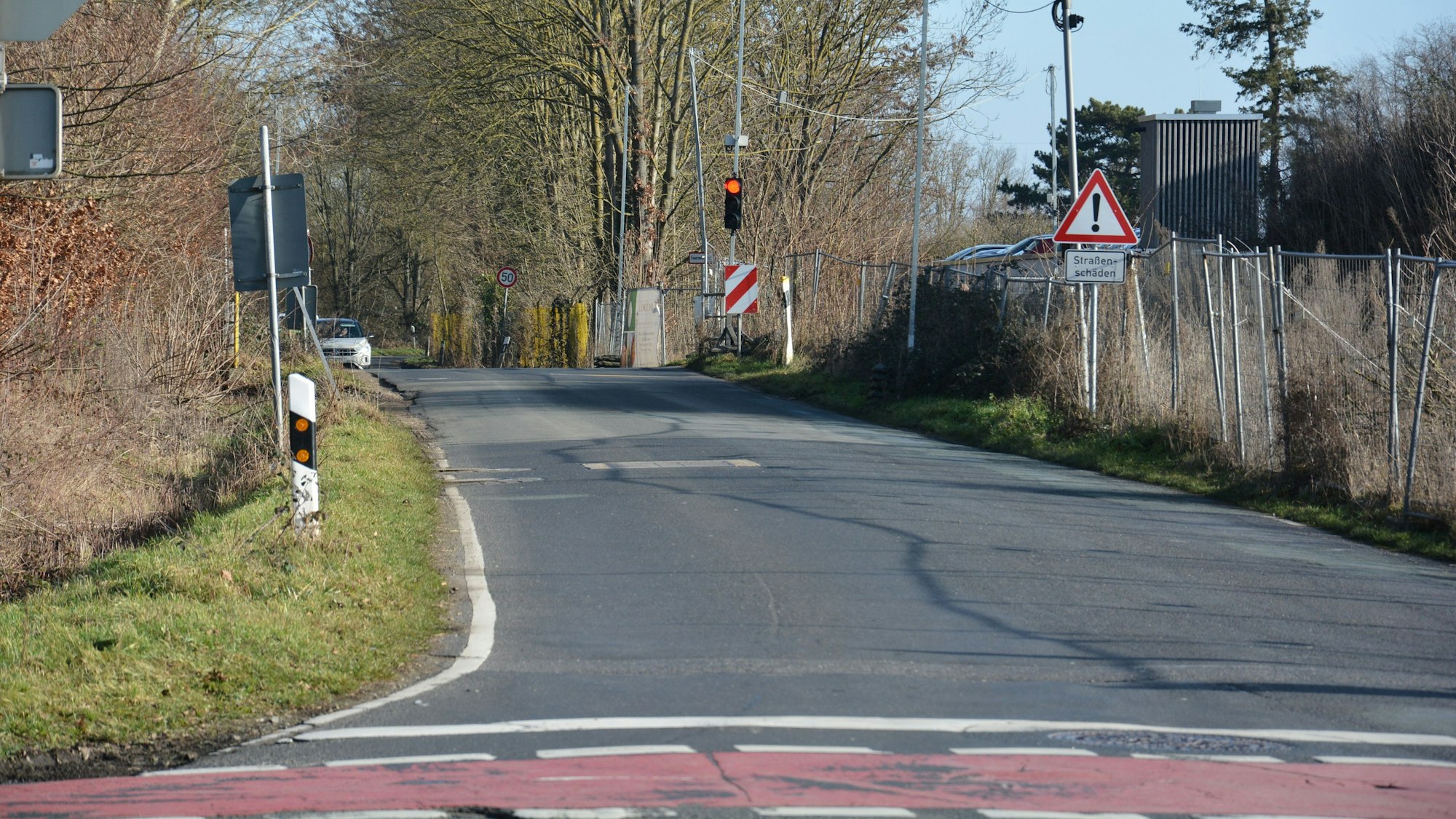 Das Bild zeigt eine Kreuzung mit Fahrradweg. Im Hintergrund ist eine weitere Kreuzung mit Ampel.