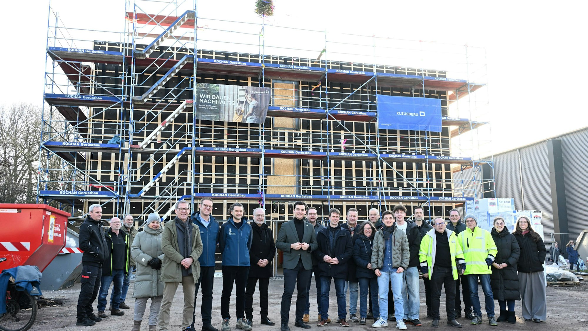 Viele Gäste stehen vor dem Rohbau