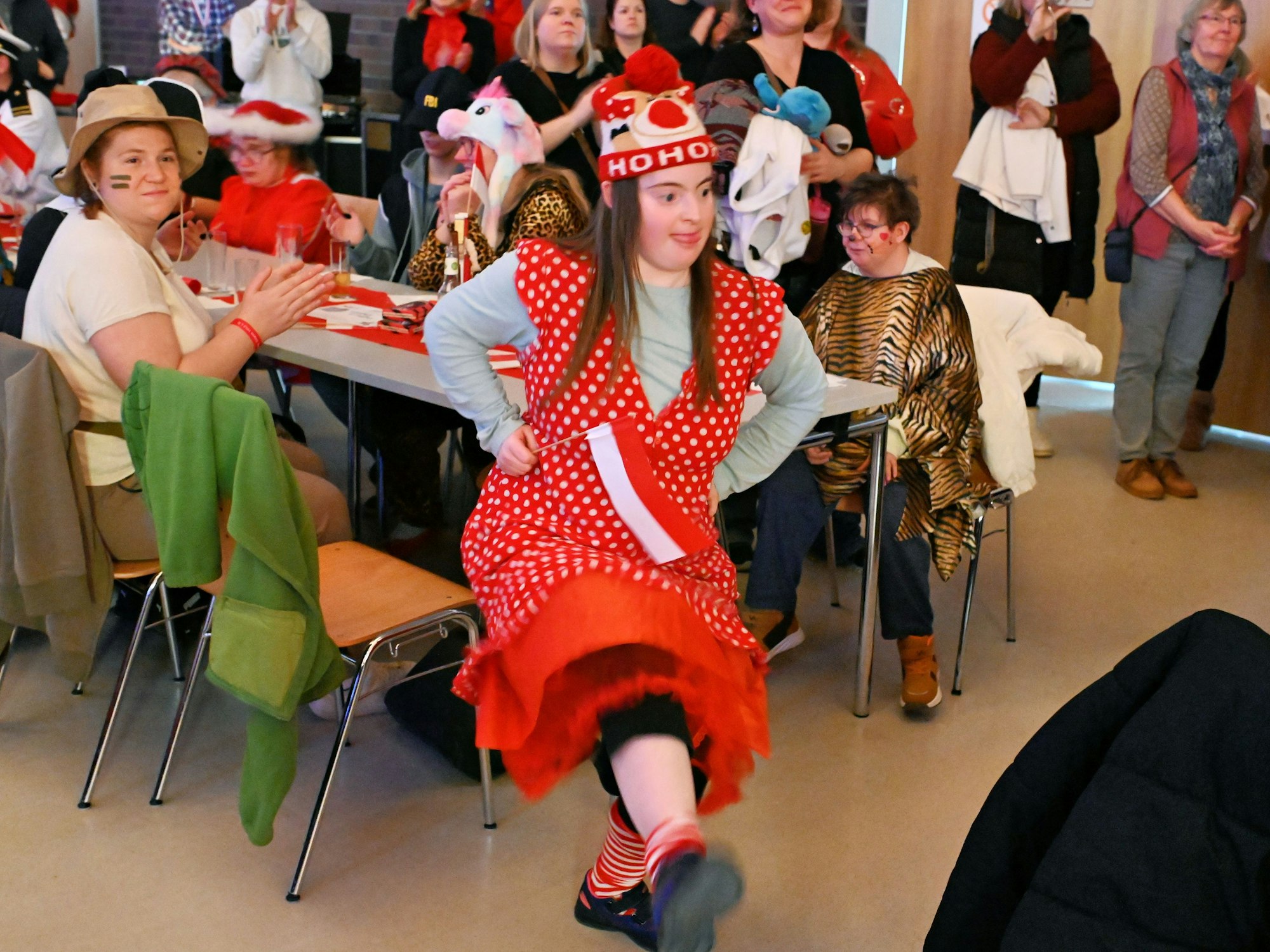 Ein Mädchen tanzt in einem Veranstaltungssaal. Im Hintergrund befinden sich weitere verkleidete Menschen.