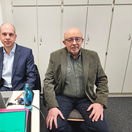 Jörg Döhler und Karl Vermöhlen sitzen nebeneinander. Döhler hat einen Laptop vor sich stehen.