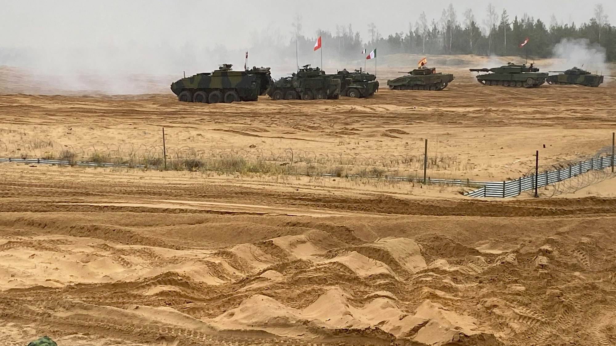 Militärfahrzeuge verschiedener Nationen nehmen an der Übung „Resolute Warrior“ teil.