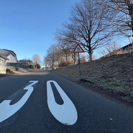 Das Bild zeigt eines der beiden Piktogramme, die Tempo 30 anordnen, auf der Berkenrother Straße in Nümbrecht-Berkenroth.