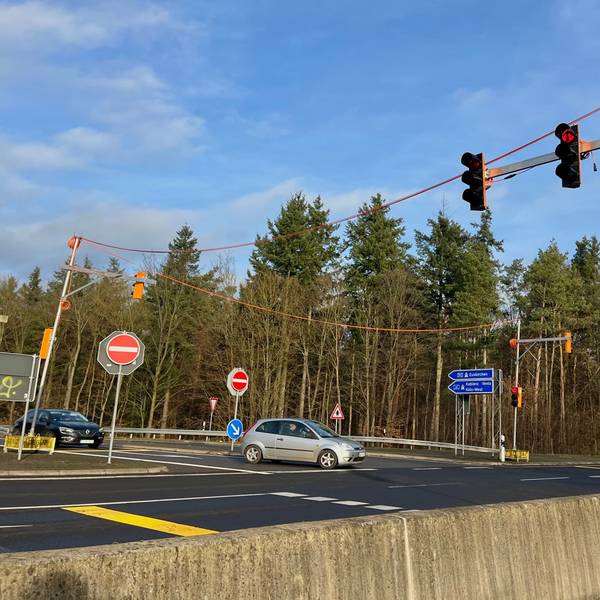 Zu sehen ist eine Ampelanlage an einer Straße.