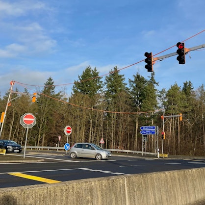 Zu sehen ist eine Ampelanlage an einer Straße.