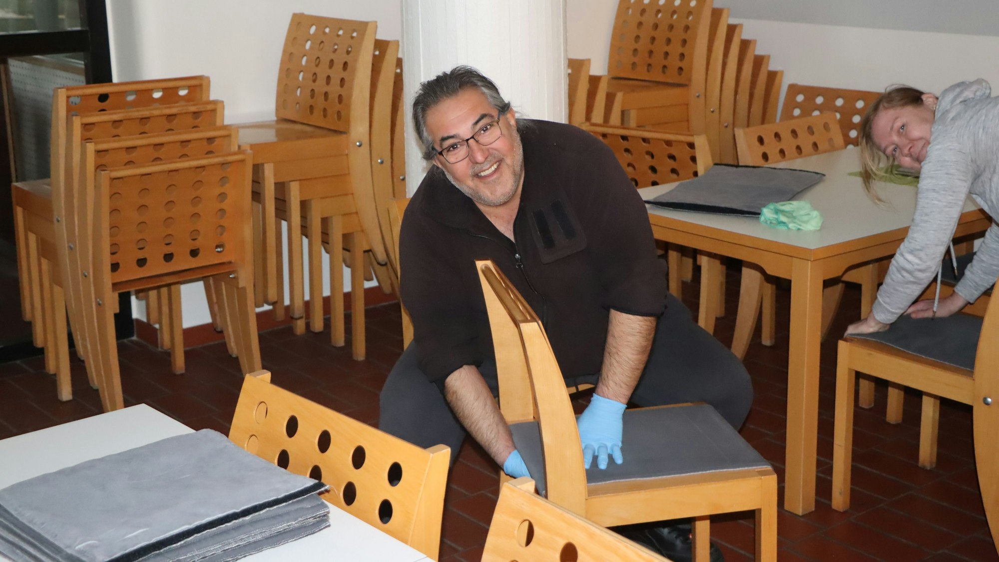 Mitarbeiter reinigen Mobiliar im Speisesaal.