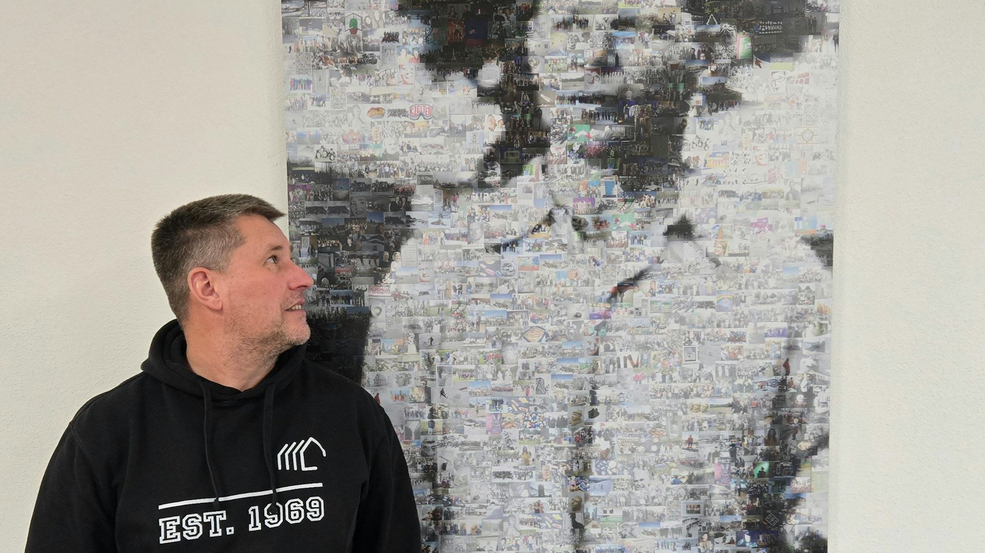 Ein Mann blickt auf ein Bild von Dietrich Bonhoeffer.