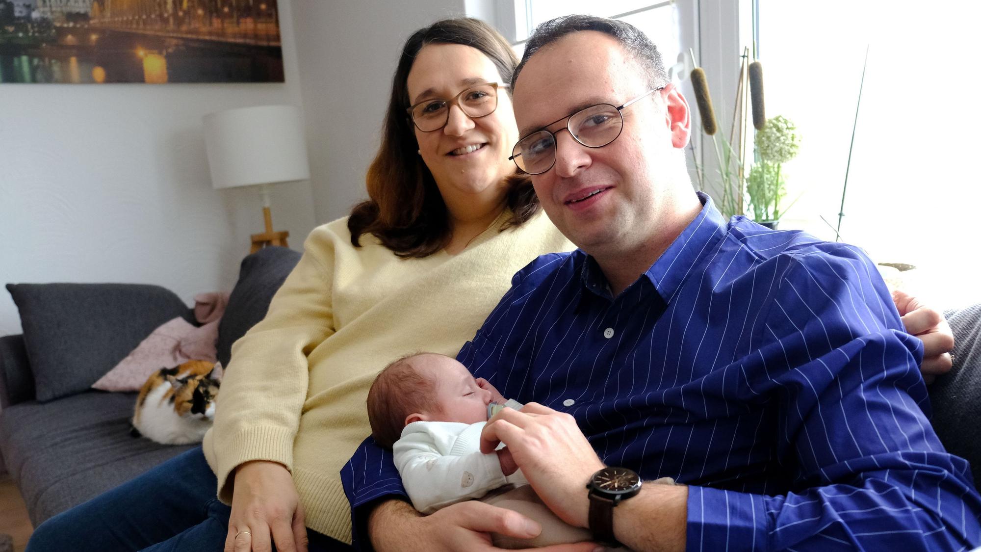 Rebecca und Richard Hein aus Kommern mit ihrem im Dezember 2025 geborenen Sohn Lennard auf dem Sofa im heimischen Wohnzimmer.
