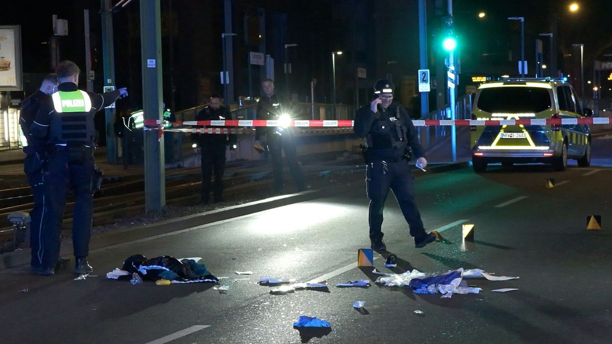 Das Bild zeigt Einsatzkräfte der Polizei, die einen mit Flatterband abgesperrten Tatort auf einer Straße untersuchen. Nach Schüssen in der Dortmunder Nordstadt ist ein Mann gestorben. Foto: Justin Brosch/dpa