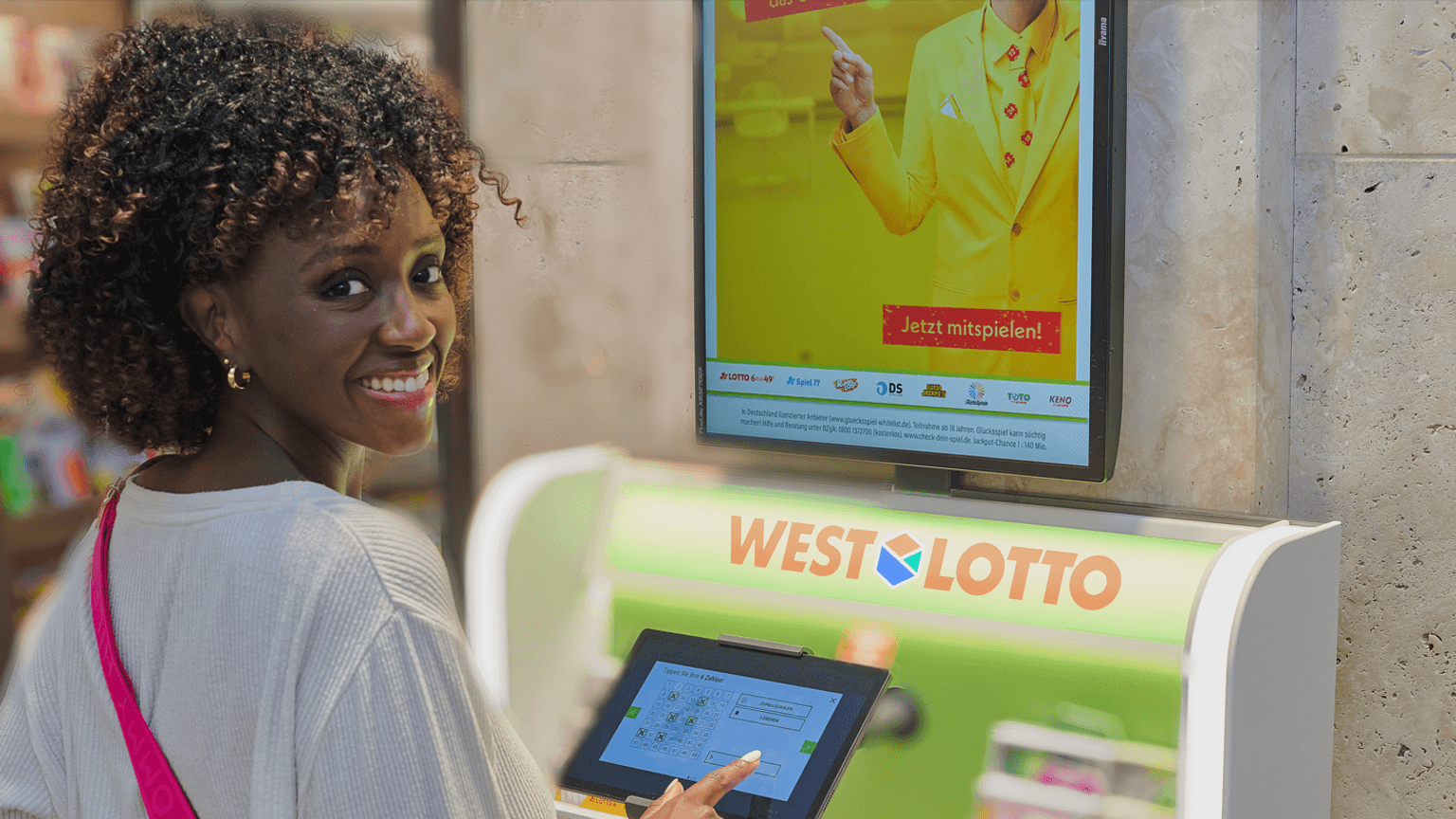 Eine Frau gibt ihren Tipp für das Spiel LOTTO 6aus49 an einem WestLotto Stand ab.