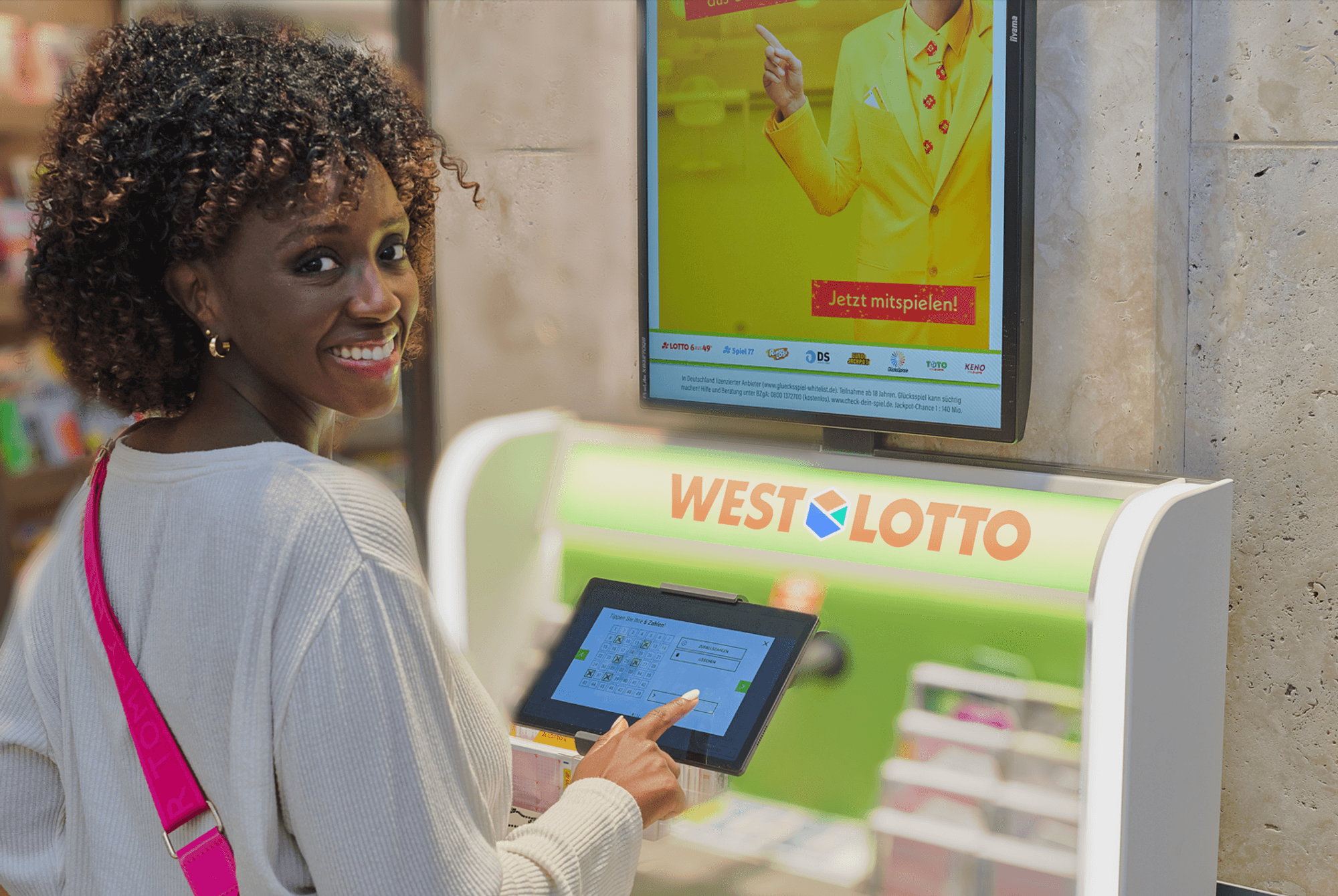 Eine Frau gibt ihren Tipp für das Spiel LOTTO 6aus49 an einem WestLotto Stand ab.